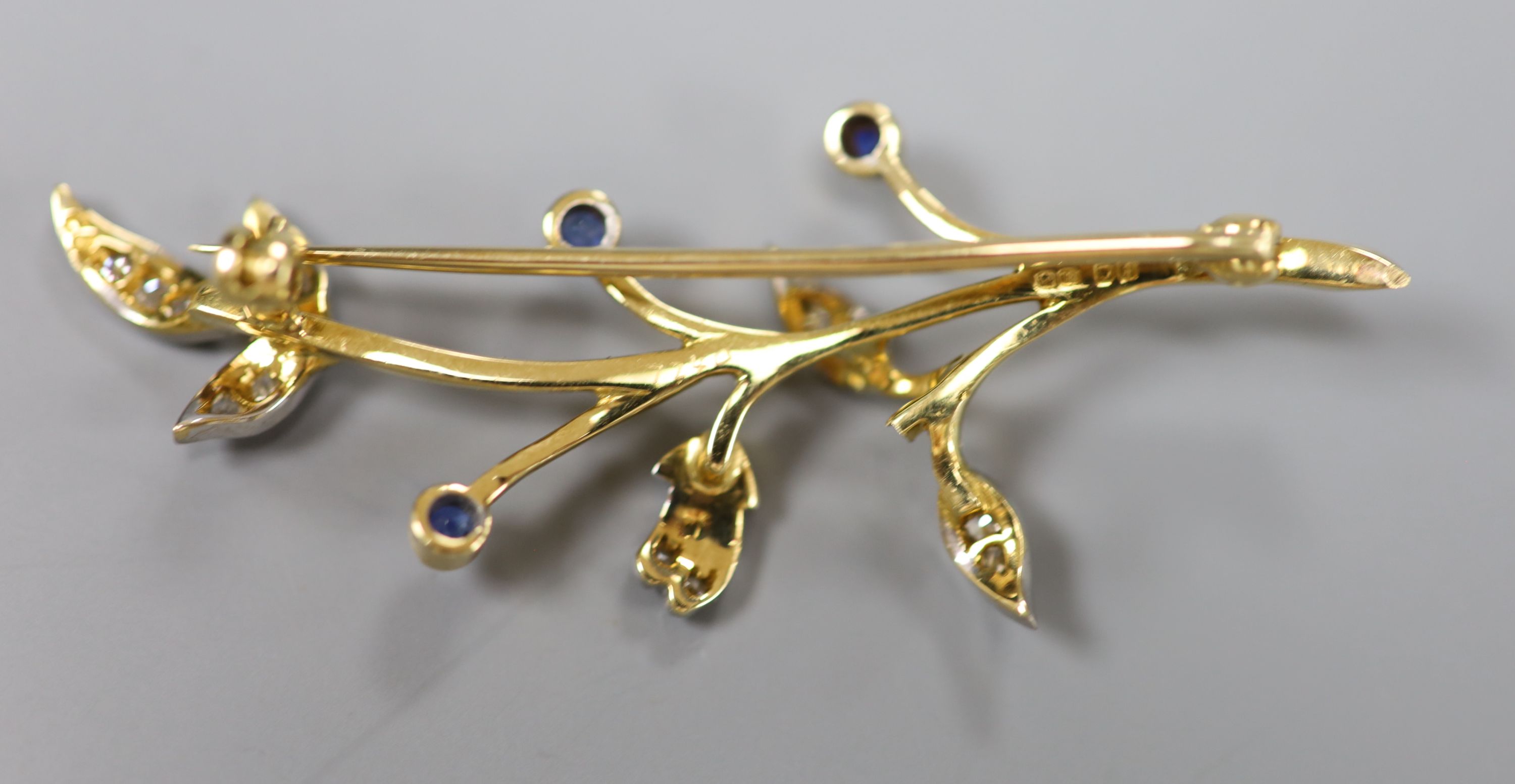 A 1960s 18ct gold, sapphire and diamond set foliate spray brooch, 54mm, gross 6.7 grams.